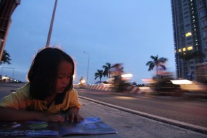 Về chiều, khi ánh đèn đường đã lên thì các bé thường tập đọc, tập viết ngay trên vỉa hè.